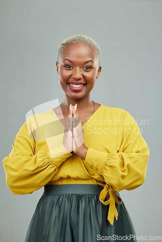 Image of Gratitude, praying hands and portrait of happy woman in studio with thank you sign on wall background. Face, together hand and smile by female person showing gratitude, prayer and worship emoji icon