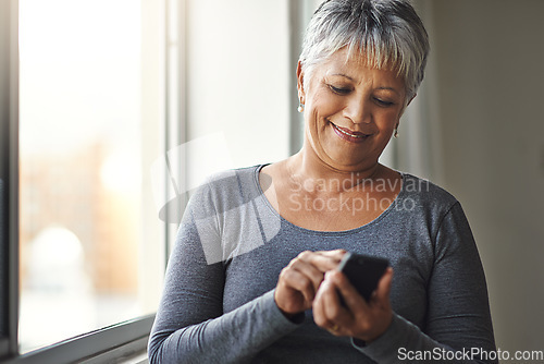 Image of Window, typing and senior woman with a cellphone, social media and mobile app at home. Mature female, happy model and old lady with a smartphone, email and happiness with network and online reading