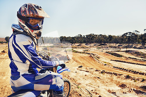 Image of Portrait, motorcycle and man on a dirt track for action, competition or a sports race outdoor. Ride, bike and power with a male athlete sitting on a motorbike for training, practice or preparation