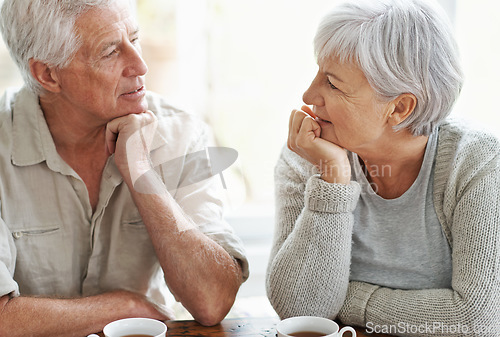 Image of Senior couple, talking and drinking tea in home for conversation, communication and quality time together. Old man, elderly woman and chat with cup of coffee for break, retirement and romantic love