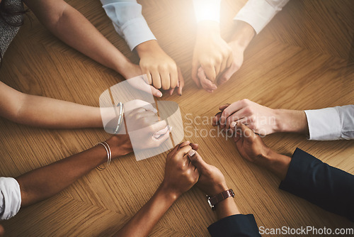 Image of Support, diversity and people holding hands by a table at a group counseling or therapy session. Gratitude, trust and friends in a circle for praying together for religion, community and connection.