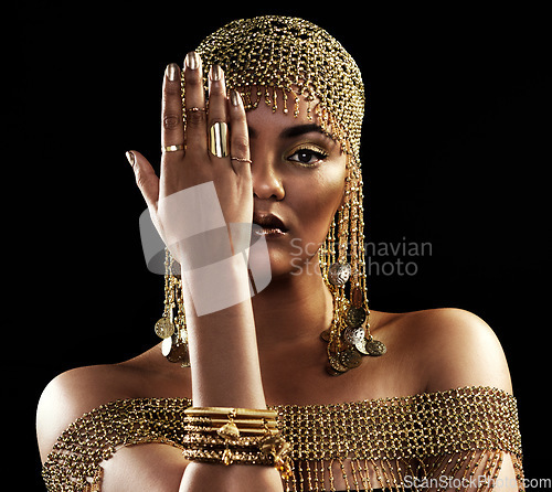 Image of African woman, portrait and gold jewelry with beauty and cosmetics in a studio. Isolated, black background and young female queen with crown, Egypt fashion and style with hand over face