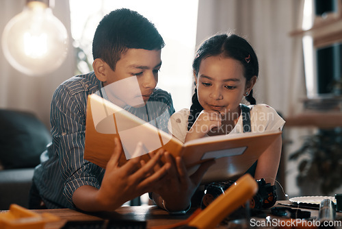 Image of Education, children reading a book and in a living room at their home. Research information, knowledge or study and young siblings with textbook learning together as a team with robotics on table