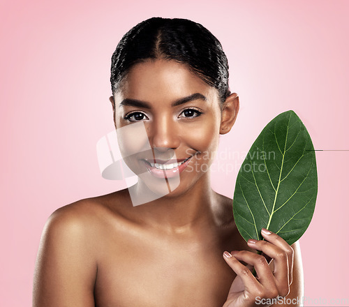 Image of Portrait, face and happy woman with leaf for skincare in studio, pink background and organic dermatology. African model, leaves and eco friendly beauty, natural shine and sustainable plant cosmetics