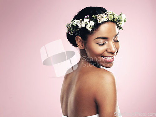 Image of Woman, crown and flowers in hair, pink background and studio for natural beauty, plants and mockup. Happy african model, skincare and floral wreath for sustainability, eco friendly cosmetics and glow