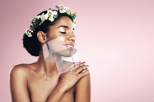 Image of Woman, flower crown and natural beauty in studio, pink background and aesthetic plants with mockup. Happy african model, skincare and floral wreath in hair for sustainable cosmetics, shine and glow