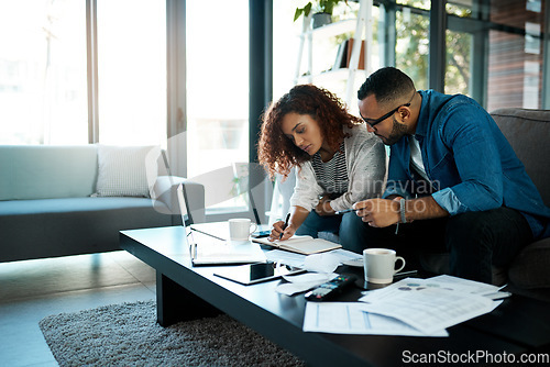 Image of Couple working on budget, finance and bills with notes on payment for loan, mortgage and debt while at home. Financial review of spending, income and savings with man and woman writing in notebook