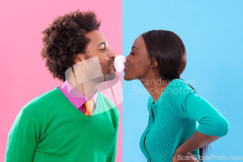 Image of Love, kiss and bubblegum with a black couple in studio on a color wall background for playful romance. Fashion, style or retro with a man and woman blowing bubbles together while bonding or dating