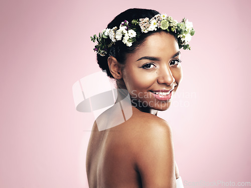 Image of Portrait of happy woman, flowers and crown in studio, pink background and aesthetic of natural beauty, mockup and glow. Face of african model, skincare and floral hair wreath for eco friendly makeup