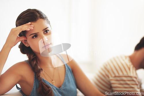 Image of Unhappy, conflict or sad with a couple fighting on a sofa in their home living room about an affair or breakup. Depression, abuse or domestic violence with a woman thinking of breakup while arguing