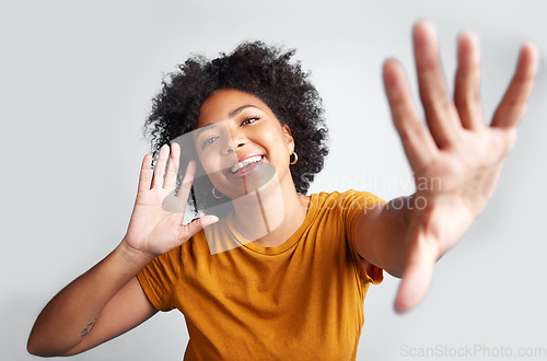 Image of Portrait, young woman and posing with hand on ear gesture smiling or being cheerful with wide open palm on grey studio background. Model, natural and pose for happiness or excitement