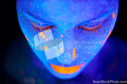 Image of Art, facial and woman with neon paint in studio for fantasy, creative or psychedelic aesthetic. Illusion, creativity and female model with glitter and bright color facial cosmetics by dark background