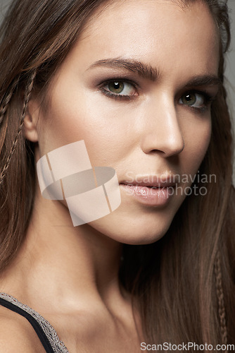 Image of Woman, closeup and face in natural beauty with makeup for skincare, contour or foundation against a grey studio background. Portrait of female person or model looking with cosmetic facial treatment