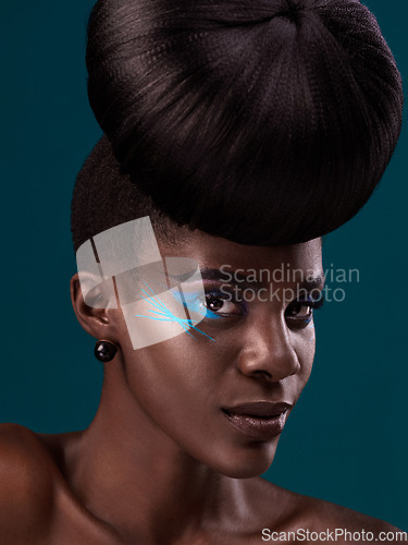 Image of Portrait, hair and cosmetics with a model black woman in studio on a blue background for beauty. Face, haircare and makeup with an attractive young female person at the salon for fashion or styling