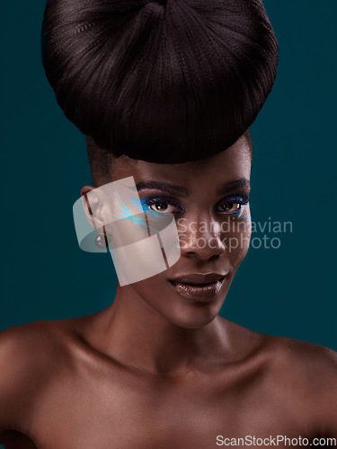 Image of Portrait, hair care and makeup with a model black woman in studio on a blue background for beauty. Face, hairstyle and cosmetics with a beautiful young female person at a salon for fashion or styling