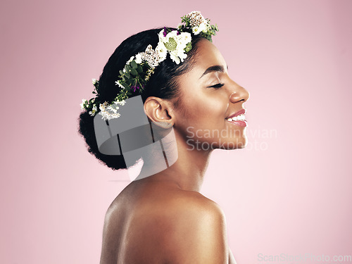 Image of Woman, smile and beauty of flower crown in studio, pink background and spring aesthetic. Face of happy african model, natural skincare and floral hair wreath for vegan cosmetics, makeup and shine