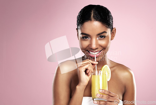 Image of Portrait, happy woman and glass of orange juice in studio for healthy nutrition, vitamin c diet or mockup on pink background. African model, fruit cocktail and citrus drink for natural skincare detox