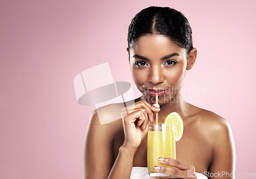 Image of Portrait of woman, glass and orange juice in studio for healthy nutrition, vitamin c or mockup on pink background. African model drinking fruit cocktail, citrus smoothie and natural diet for skincare