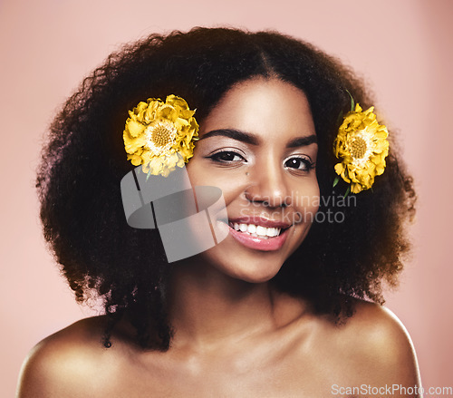 Image of Portrait of happy woman, hair care and face with yellow flowers, natural beauty or pink background in studio. African model, skincare and daisy plants in afro for sustainable cosmetics, smile or glow