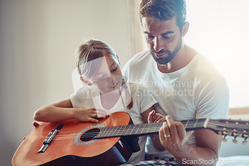 Image of Father with daughter, guitar with teaching and learning at home, bonding with love and creativity. Family, man and girl learn to play musical instrument, lesson and music education with talent