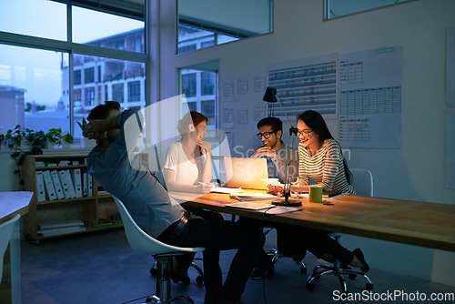 Image of Collaboration, night and a business team working in the boardroom for planning, strategy or innovation. Meeting, teamwork and overtime with a group of employees at work on a laptop in the evening