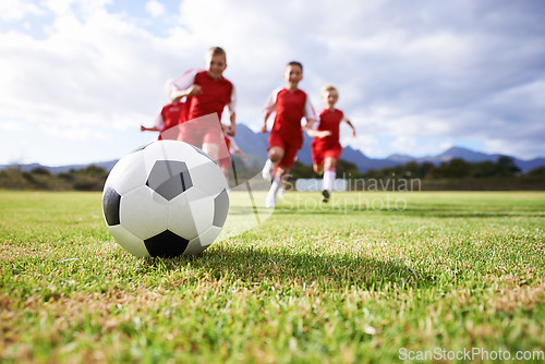 Image of Running, teamwork and sports with children and soccer ball on field for training, competition and fitness. Game, summer and action with football player and kick on pitch for goals, energy and athlete