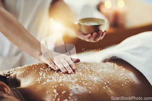 Image of Woman, hands and relax in salt scrub for skincare, exfoliation or relaxation at indoor beauty spa. Hand of masseuse rubbing salts on female back for physical therapy, massage or treatment at resort