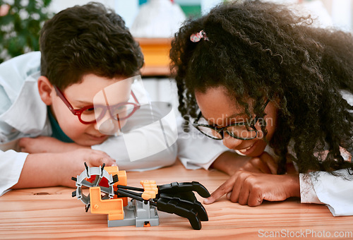 Image of Engineering, learning and children building a robot hand together in a classroom at school and being curious. Clever, education and young engineer students working in a science class doing research