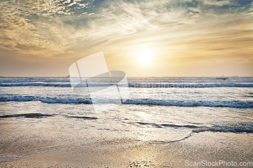 Image of Beach, water and ocean with sunrise and mockup with blue sky and waves on horizon. Sea landscape, outdoor and nature with sunshine at the coast and seaside with sand and no people with clouds