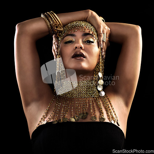Image of Fashion, portrait and woman in studio with gold, beauty and royal, jewellery or attitude on black background. Face, queen and lady model pose in luxury accessory for cosplay, rich or aesthetic makeup