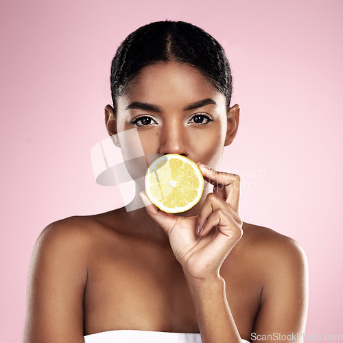 Image of Portrait, woman and lemon for beauty in studio, pink background and wellness of vitamin c cosmetics. Face of african model, citrus fruits and nutrition for skincare, organic benefits and natural diet
