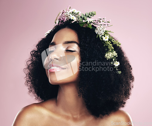 Image of Woman, face and flower crown for beauty in studio, pink background and natural glowing skincare. African, female model and floral wreath of plants, sustainable cosmetics and eco friendly dermatology