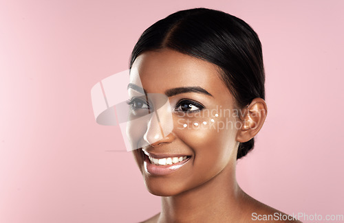 Image of Thinking, skincare and face of woman with eye cream in studio isolated on pink background mockup. Dermatology, creme cosmetics and happy Indian female model with moisturizer lotion for healthy skin.
