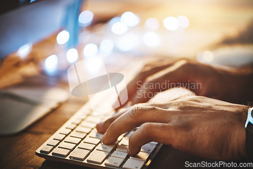Image of Hands, keyboard and closeup of man typing while doing research on a computer in the office at night. Professional, technology and male employee working overtime on a deadline project in the workplace
