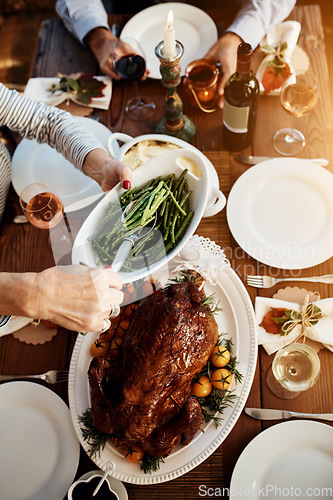 Image of Food, table and hands of family eating healthy beans and chicken or turkey together for holiday celebration. Above people or friends serving vegetables for lunch or dinner with drinks at a house