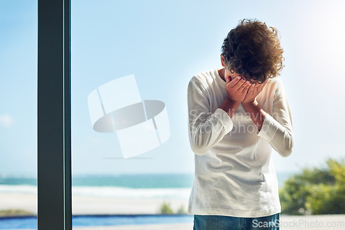 Image of Sad, depression and crying child with hands covering face while lonely and unhappy. Depressed, psychology and scared boy kid with anxiety problem, grief or upset in isolation in a house