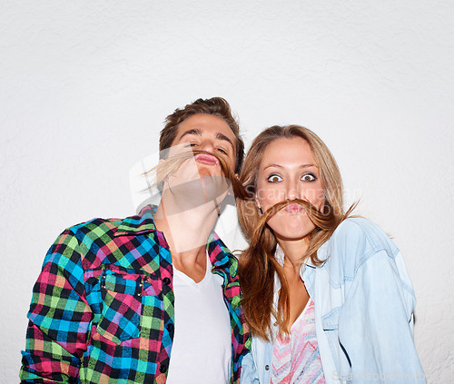 Image of Portrait, funny and couple with moustache hair, silly and happiness isolated against a grey studio background. Face, man and woman with facial expression, goofy or partners with joy, bonding and love