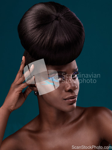 Image of Portrait, beauty and hair with an african woman in studio on a blue background for makeup or cosmetics. Face, haircare and fashion with an attractive young female model at the salon for trendy style