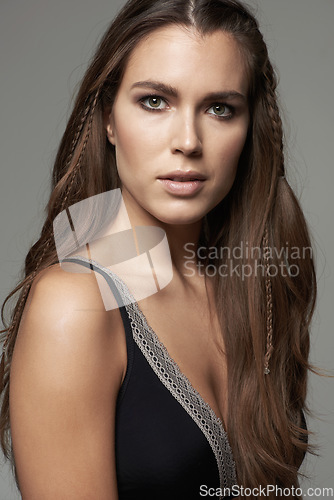 Image of Woman, face and portrait in natural beauty of model posing with long hairstyle or makeup against a grey studio background. Isolated young and confident female person with facial cosmetics on backdrop