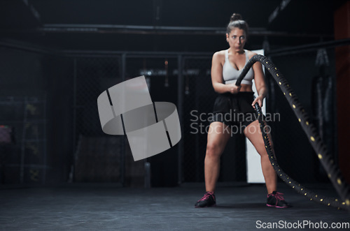 Image of Sports, battle ropes and woman at the gym doing strength, cardio and challenge exercise with space. Fitness, energy and strong female athlete doing health workout or training with equipment for power