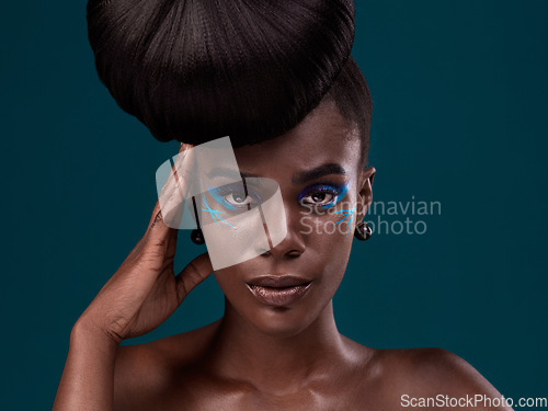 Image of Portrait, hair and makeup with a model black woman in studio on a blue background for beauty. Face, haircare and cosmetics with an attractive young female person at the salon for fashion or styling