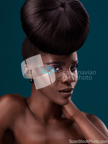 Image of Portrait, cosmetics and hair care with an african woman in studio on a blue background for beauty or makeup. Eyeshadow, hairstyle and fashion with an attractive young female model at the salon