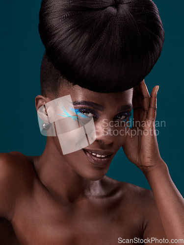 Image of Portrait, makeup and happy with an african woman in studio on a blue background for hair or cosmetics. Eyeshadow, smile and fashion with an attractive young female model at the salon for style