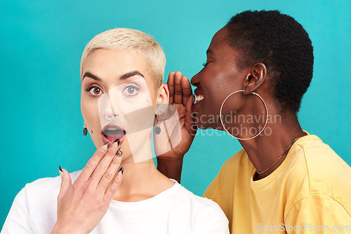 Image of Surprise secret, shock and girl friends portrait with privacy, laugh and gossip in a studio. Blue background, women and smile of a female person with whisper and news telling a story and listening