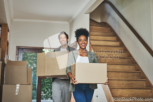 Image of Happy couple, real estate and moving in new home with boxes for renovation, investment or relocation. Interracial man and woman owner carrying box for property rent, mortgage loan or move together