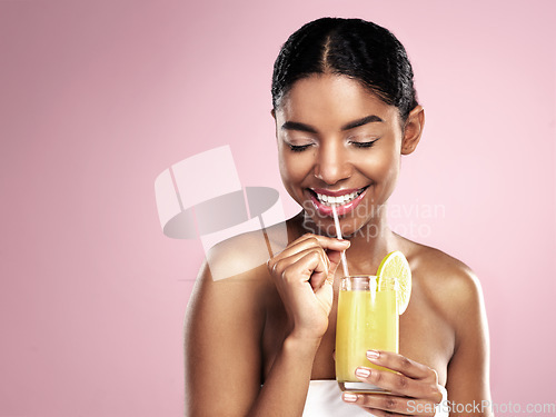 Image of Happy woman drink glass of orange juice in studio, pink background and mockup for healthy skincare. African model, fruit cocktail and smoothie for nutrition benefits, natural beauty or vitamin c diet