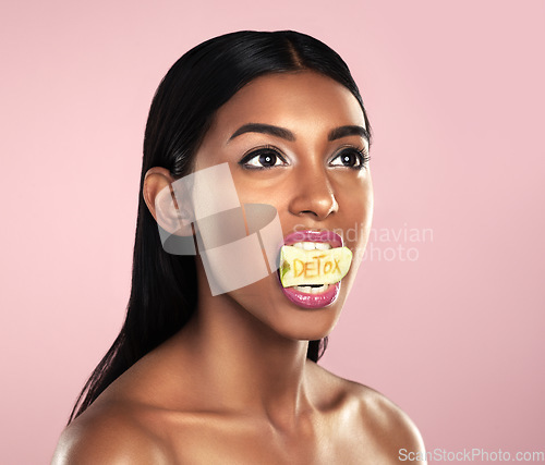 Image of Detox, fruit and woman with apple in her mouth for beauty empowerment isolated in a studio pink background. Skincare, food and female model or person on diet for self love or cosmetic care