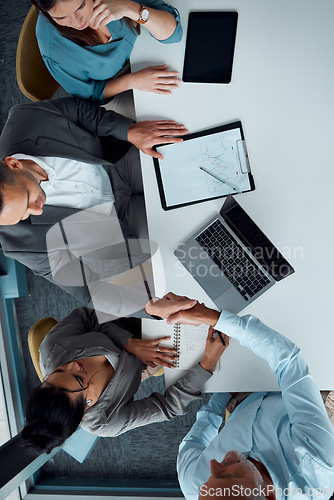 Image of Business people, handshake and laptop for top view meeting, partnership deal and b2b interview collaboration in office. Contract, onboarding celebration and shaking hands for agreement or welcome