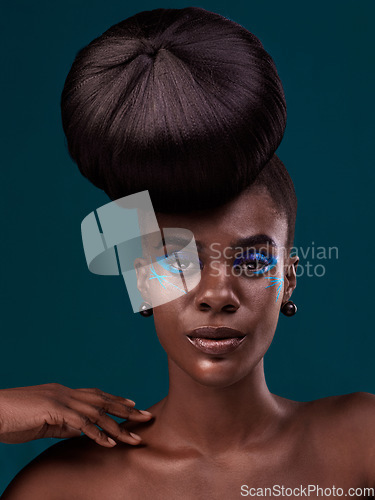 Image of Portrait, hair and makeup with an african woman in studio on a blue background for beauty or cosmetics. Face, haircare and fashion with an attractive young female model at the salon for trendy style