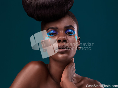 Image of Portrait, makeup and glamour with an african woman in studio on a blue background for hair care or cosmetics. Face, confidence and fashion with an attractive young female model at the salon for style